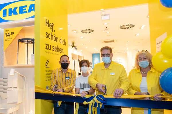 IKEA Kollegen stehen vor dem Eingang des IKEA Pop-up in Wolfsburg, sie tragen Masken.