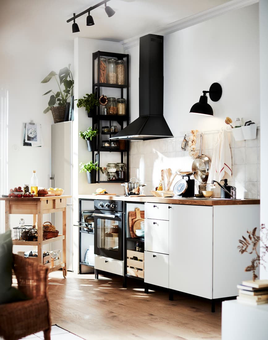 IKEA Küchenlösung mit weißem Unterschrank mit hölzerner Arbeitsplatte, mit einem Holz-Beistelltisch und Dekorativen Pflanzen