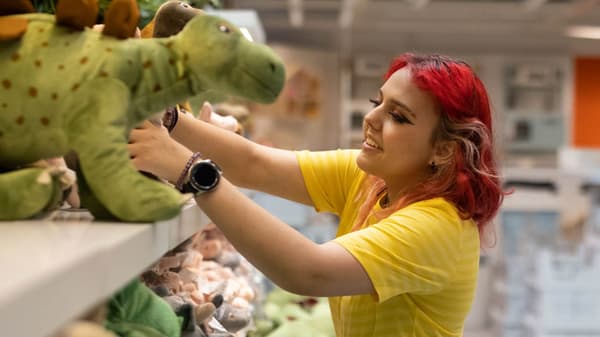 IKEA Lehrling. Im Hintergrund sieht man Stühle.