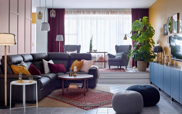 IKEA LIDHULT 4-seat dark brown leather corner sofa in a living room with tiled flooring and PERS HAMADAN red oriental rug.