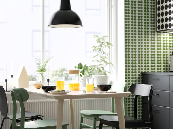 IKEA LISABO light ash veneer dining table, green RÖNNINGE chairs and SVENBERTIL black chairs in a dining room setting.