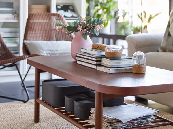 IKEA LISTERBY rectangular brown coffee table long, storing books and boxes on a slated shelf below.