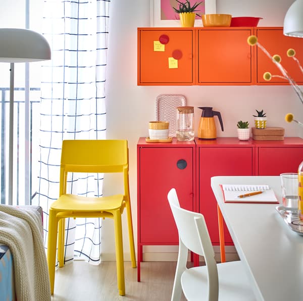 IKEA LIXHULT bright red and orange powder coated metal cabinets by the dining area.