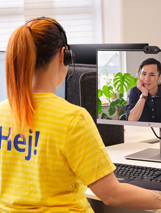 IKEA medarbejder sidder foran en skærm og har online rådgivning med en kunde. Kunden ses på skærmen.