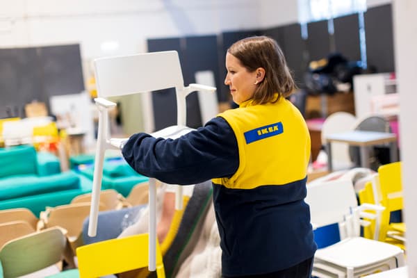 IKEA-medarbetare lyfter vit stol