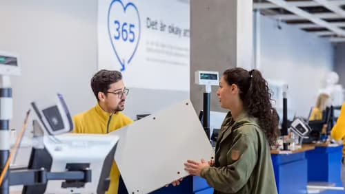 IKEA medarbetare som hjälper en kund med en retur på lagret.