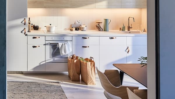 IKEA METOD keuken met lichthouten deurfronten met esseneffect en een platgeweven vloerkleed gemaakt van jute en wol.