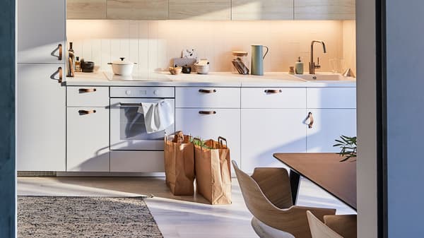 IKEA METOD kitchen with light wooden ash-effect door fronts and a flatwoven rug made from jute and wool.