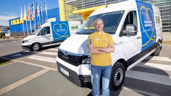 IKEA Mitarbeiter in gelbem T-Shirt steht vor einem weiße Ikea Lieferwagen