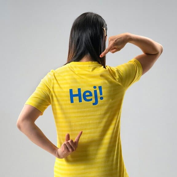 IKEA mitarbeiterin mit gleben Tshirt und der aufschrift "HEJ!"