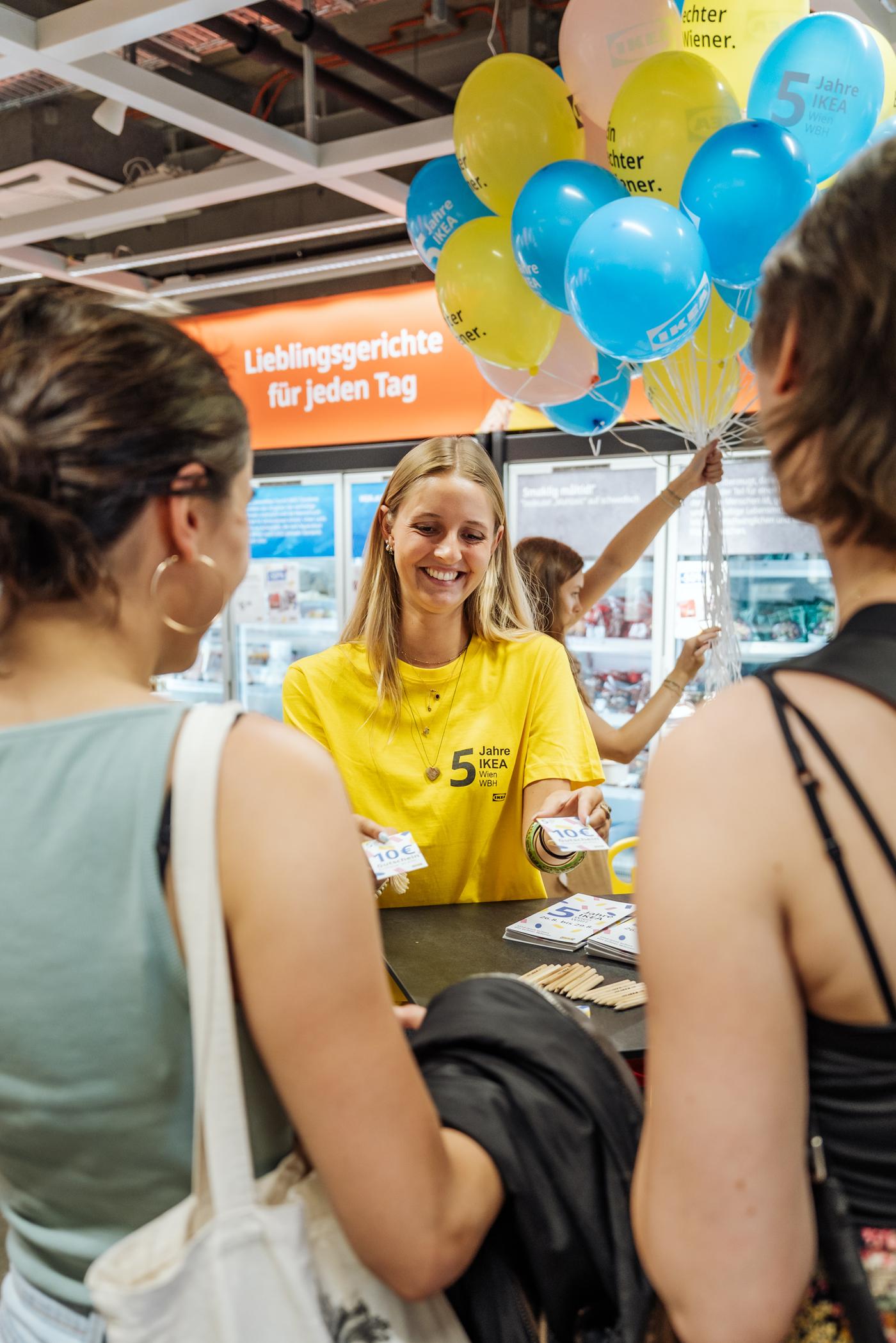 IKEA Mitarbeiterin verteilt Goodies am Eingang von IKEA Wien Westbahnhof.