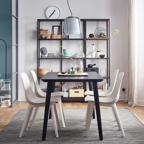 IKEA ODGER recycled plastic white chairs and black LISABO table, arranged in a dining area space.