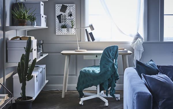 IKEA offre un'ampia scelta di soluzioni per creare uno spazio di lavoro moderno e funzionale in soggiorno, come la sedia girevole ÖRFJÄLL/SPORREN. La coperta verde che l'avvolge crea una continuità di stile con il resto della stanza - IKEA