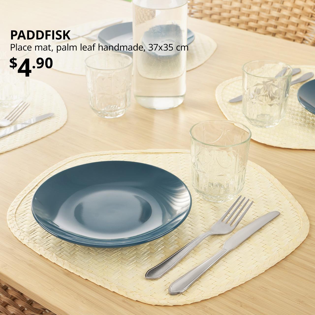 IKEA PADDFISK place mat with a bowl, glass cup and fork and knife placed on top of it on LISABO dining table. Price: $4.90.
