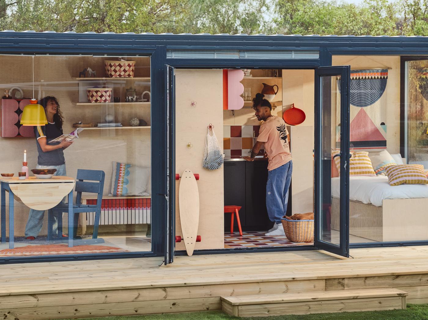 IKEA päsentiert die farbenfrohe Kollektion OMMJÄNGE in einem modernen, blauen Tiny House mit großen Glasfronten. 