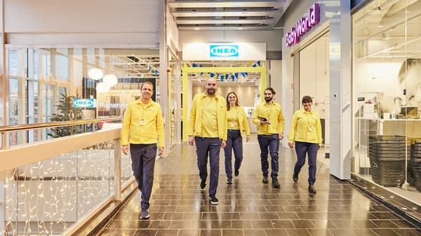 IKEA personal i gul IKEA unifrom står framför ingången till en IKEA paneringsstudio