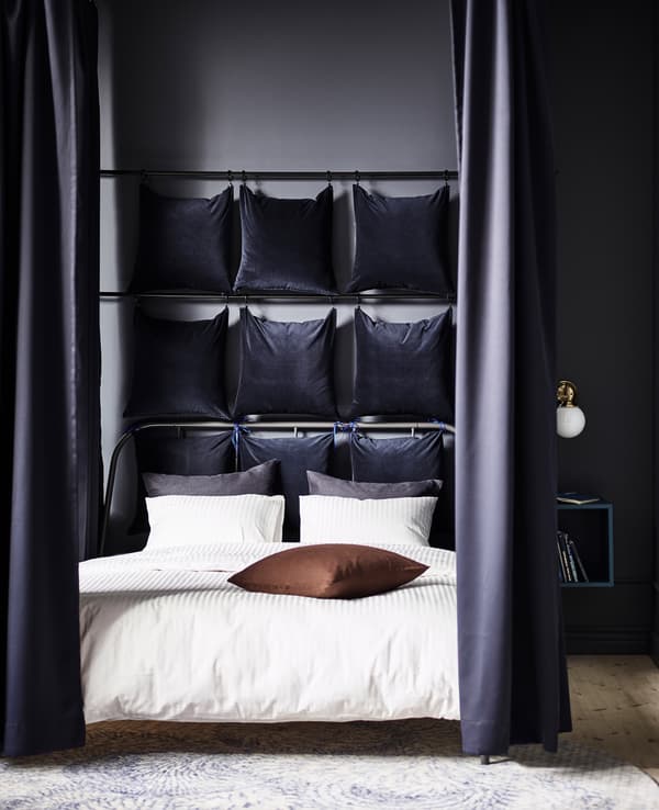 IKEA peut vous aider à transformer n’importe quel cadre de lit en cocon paisible. Isolez simplement le lit dans la pièce en créant une cloison angulaire à l'aide de rails et de crochets fixés au plafond. Accrochez-y des rideaux comme SANELA, en velours de coton épais bleu foncé, pour faire écran à la lumière et atténuer les bruits.