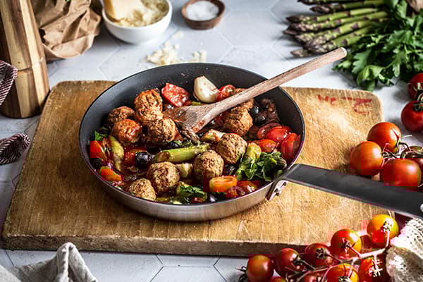 IKEA Plantbullar und weitere Zutaten werden für das Rezept vegane Pasta alla Puttanesca mit grünem Spargel und Plantbullar vermengt.