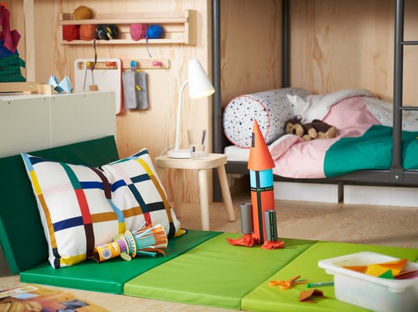 IKEA PLUFSIG green foldable gym mat with a handmade space rocket on it.