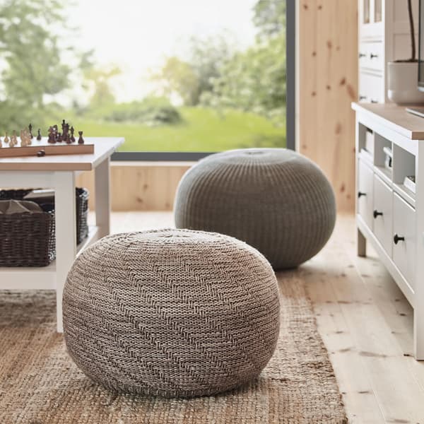 IKEA SANDARED soft beige and dark grey knitted seat pouffes in a living room.