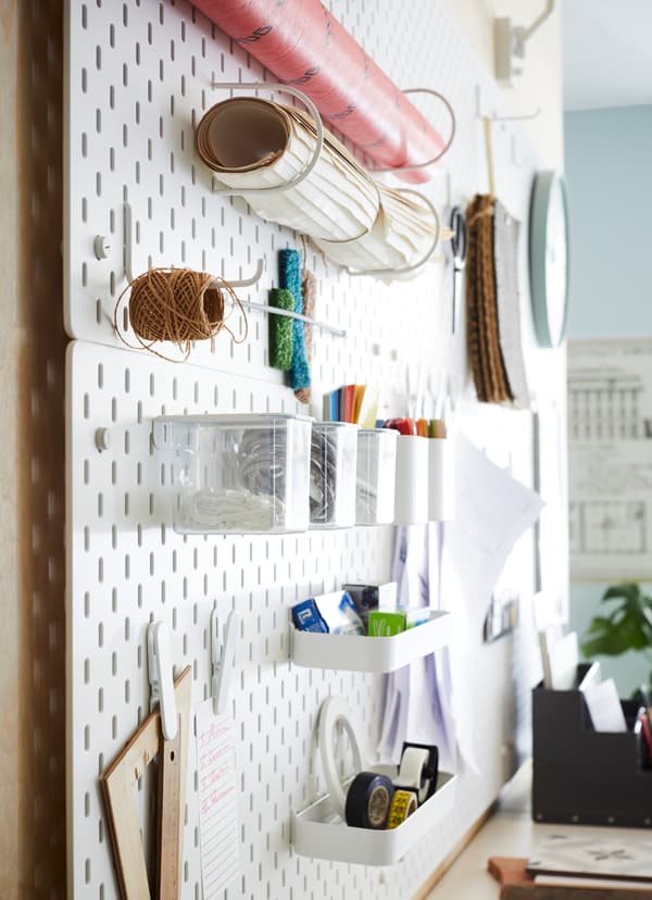 IKEA SKÅDIS white pegboards holding office supplies in a communal area of the office.