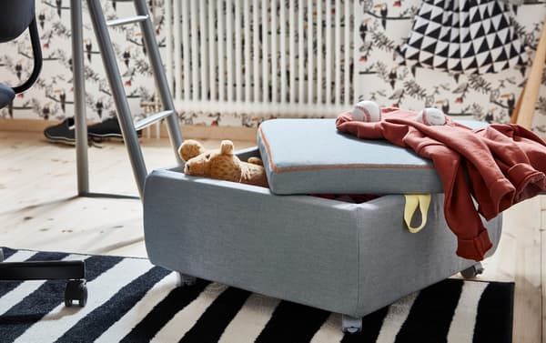 IKEA SLÄKT grey seat module propped open with stuffed toy inside.