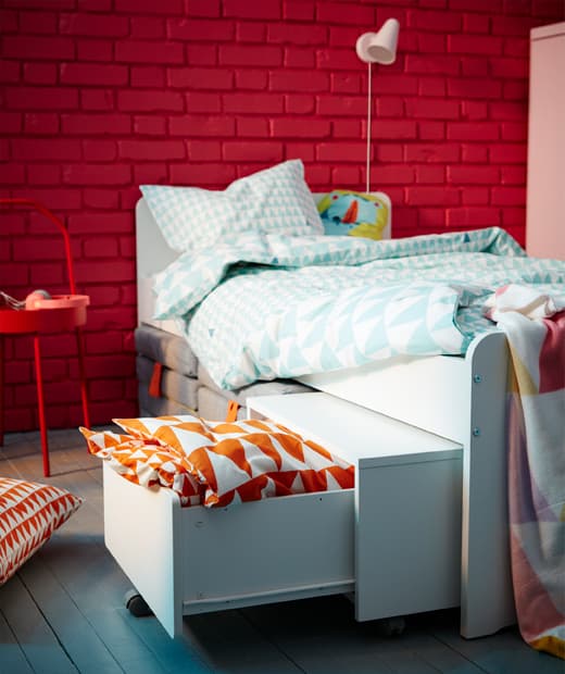 IKEA SLÄKT white bed and kid’s storage unit are a small space children’s bedroom solution. The box can store extra pillows and sheets and be wheeled out from under the bed. SLÄKT mattresses also fit underneath.
