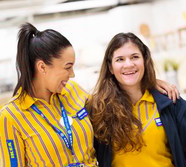 IKEA store co-workers in their office, dealing with administrative computer tasks.