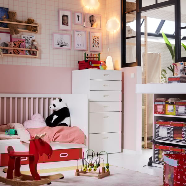 IKEA STUVA white baby furniture crib and six drawer unit in a pink children's nursery room with toys and stuffed panda bear.