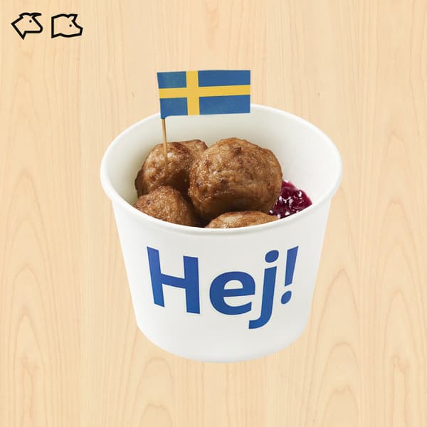IKEA-style white cup labeled “Hej!” holds Swedish meatballs with lingonberry sauce, topped by a Swedish flag on a light wood background.