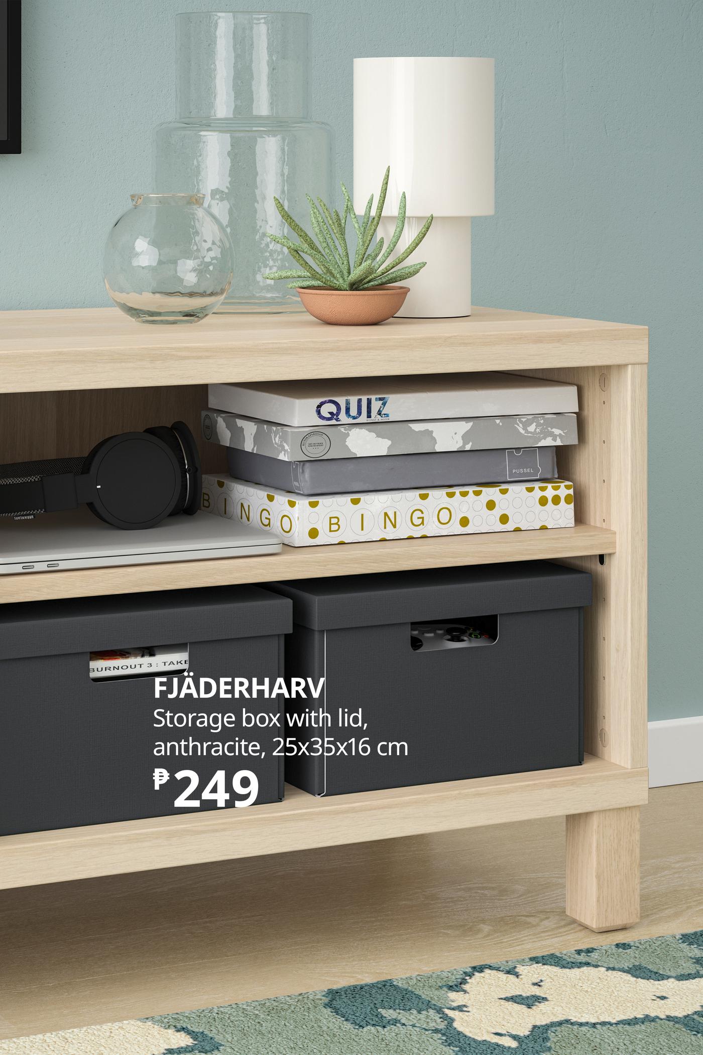 IKEA-style wooden shelving unit with plants, glass vases, lamp, books, headphones, and black storage boxes; cozy, organized room setting.