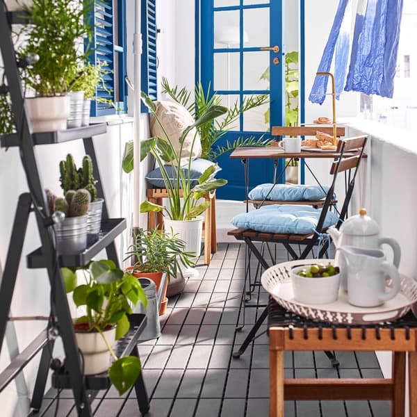 IKEA TÄRNO brown stained chairs and table in a narrow outdoor balcony.