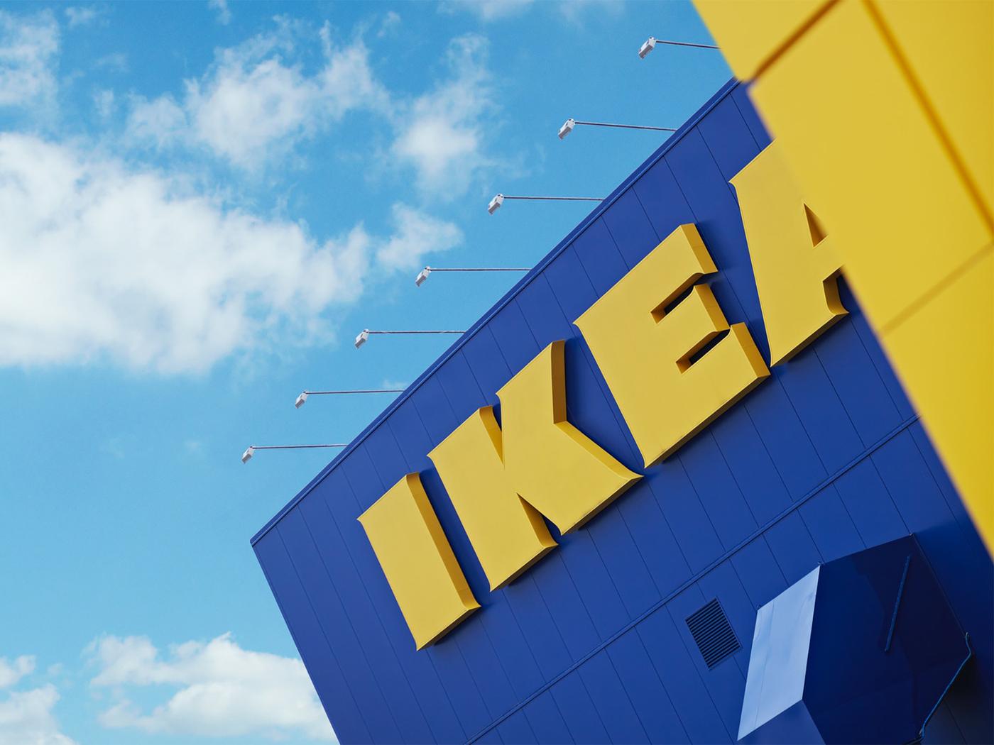 IKEA-tavaratalon sininen seinä, jossa lukee keltaisella IKEA. Tavaratalon taustalla on sininen taivas.