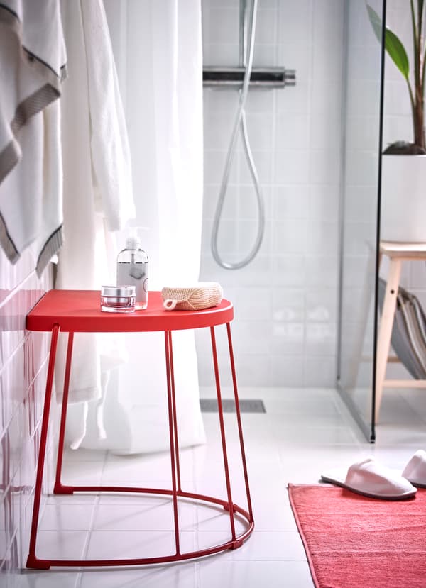 IKEA TRANARÖ red stool is a half circle shape that can be combined with another to create a side table surface. The smooth coated material withstands moisture, and can be used both indoors and outdoors.