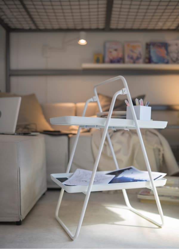 IKEA VIGGJA white plastic tray stand is foldable to fit small spaces and to easily store away. It’s perfect to place your coffee, art supplies and more.