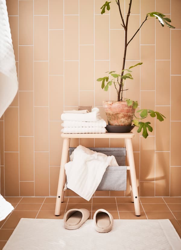 IKEA VILTO step stool with a potted plant and white hand towels on top.
