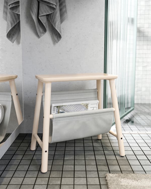 IKEA VILTO stolica od brezovine stoji van kupatila, s odloženim časopisima, u sivoj nijansi.