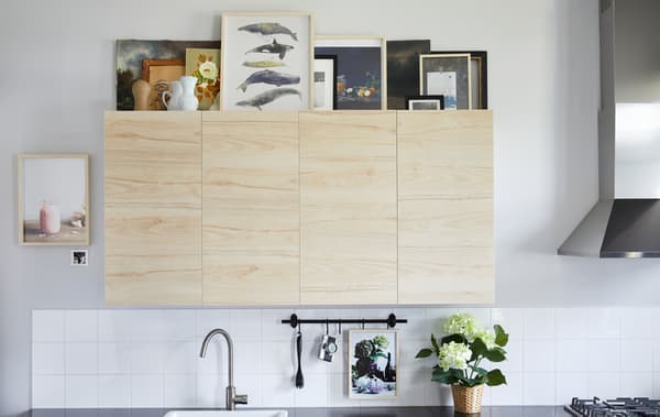 IKEA vous propose des idées pour exploiter l'espace au-dessus des éléments de cuisine, notamment en réalisant une galerie d’art. Pour éviter toute surcharge, limitez-vous à un ou deux types de finitions pour les cadres, comme HOVSTA en bouleau. Variez les tailles pour attirer l’œil et choisissez des œuvres qui s’apprécient facilement de loin.