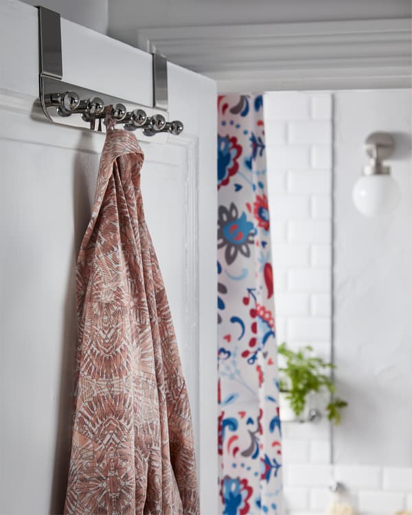 IKEA VOXNAN hanger for the door in chrome effect hangs on the bathroom door and a morning robe is hanging on it.