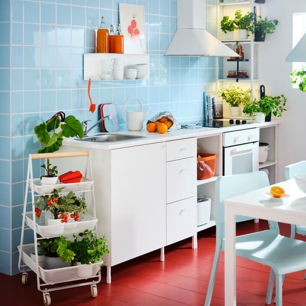 IKEA white ENHET kitchen and worktop with a blue tiled wall and red floor
