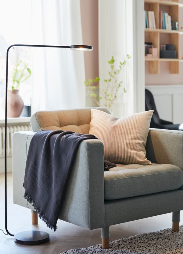 IKEA YPPERLIG LED black floor lamp, providing light to an LANDSKRONA armchair.