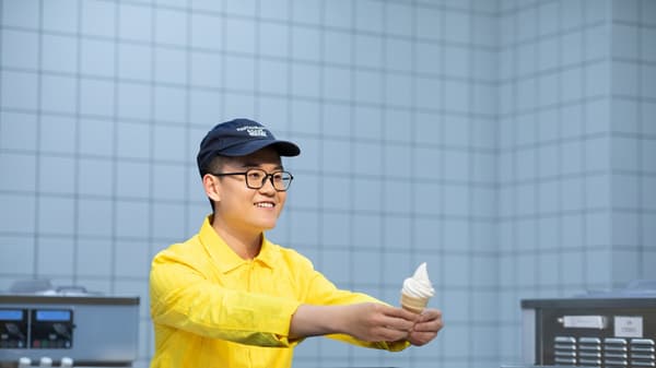 イケアのフードコワーカー（従業員）がソフトクリームをお客さまに提供している