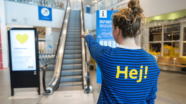 イケアのコワーカーが店舗入り口で行き先を指さしている