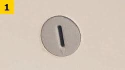 イケアの組み立て説明で、矢印付きの丸いスロットキャップが板に取り付けられたステップ1