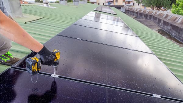 Il braccio di un operaio lavora all'installazione di un pannello fotovoltaico. 