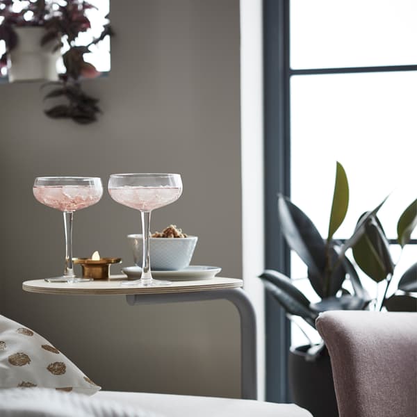 Il tavolino FLOTTEBO accanto a un divano letto in una zona lounge.