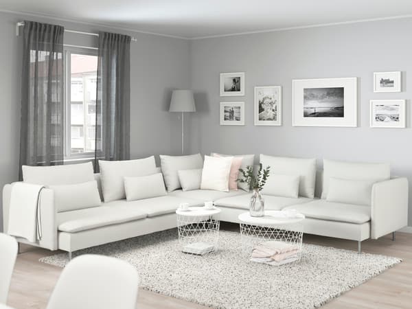 白いL字ソファを置いた広々リビング。グレーのカーテンとラグで落ち着いた北欧風インテリア。