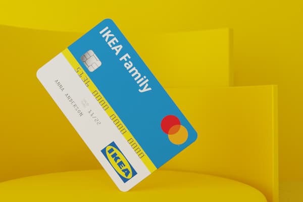 Image de la carte de crédit IKEA Family : une carte de crédit bleue et blanche avec le logo d’IKEA devant un fond abstrait jaune.