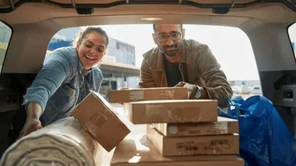 Image of a man and women loading their IKEA purchases in the back of their car