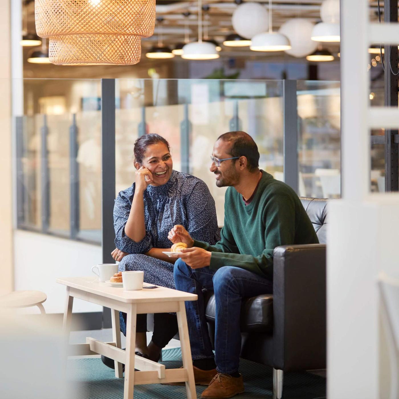 Image of a man and women smiling enjoying a cup of coffee